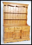 A 20th century large triple pine farmouse dresser in two parts. 3 cupboards and drawers to base,