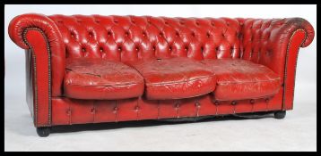 A contemporary 20th Century buttoned back  distressed red leather upholstered three seater