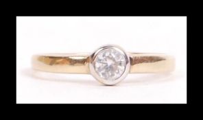 A hallmarked 9ct gold and CZ solitaire ring being set with a single round cut bezel mounted CZ.