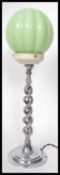 A vintage 20th century Art Deco chrome table lamp having a segmented green glass shade. The lamp