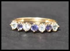 A hallmarked 9ct gold ring set with 7 white and purple alternating stones. Hallmarked Birmingham.