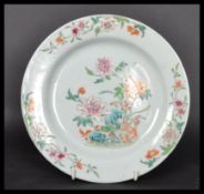An 18th century Chinese Qing Long Famille Rose plate hand painted with enamels depicting floral