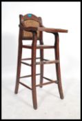 An early 20th century Chinese elm wood childs high chair having a flip over tray and foot rest.