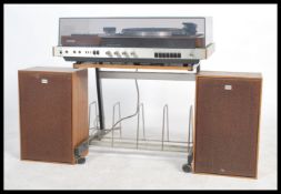 A retro 20th century Sony music hi fi system raised on a retro hi fi stand with matching speakers.