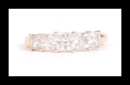 A hallmarked 14ct gold and CZ 5 stone ring being set with 5 graduated square cut CZ. Hallmarked