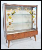 A vintage retro mid 20th century china display cabinet having glass sliding doors decorated with