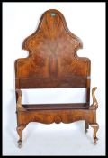 A 1920's walnut Queen Anne revival single bed having oversized walnut headboard with shaped form