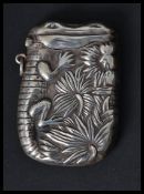 A silver vesta case having an embossed image of a crocodile. Weighs 29.7 grams.