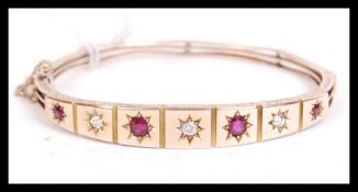 A 19th century Victorian 15ct gold diamond and ruby bangle bracelet being set with three old cut