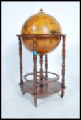 An antique style cocktail drinks cabinet in the form of a globe with hinged top section to fitted