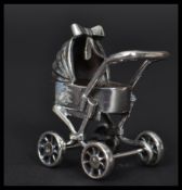 A sterling silver miniature model of a pram / perambulator. Weighs 21.3 grams.