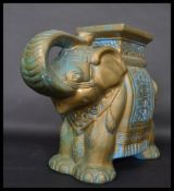 A Chinese 20th century ceramic plant stand in the form of an elephant having a green, blue and white