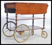 A retro 20th century laquered mahogany buffet serving trolley with large wheels and handle top one