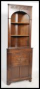 A Jacobean revival Jaycee / Old Charm style oak corner cabinet having an open window shelving unit