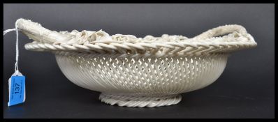 A mid 19th century Irish Belleek ceramic basket having lattice work with ribbon edges decorated with