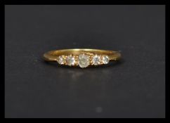 An 18ct gold ring set with 5 graduating old cut diamonds. Marked 18ct, mark worn, tests 18ct gold.