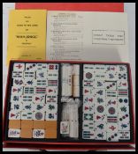 A vintage 1960's Oriental Mahjong set having wooden and resin playing pieces held within a vinyl box