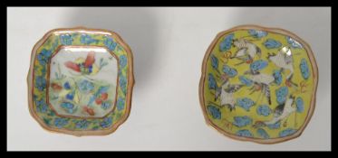 A non matching pair of Chinese famille jaune  table salts raised on pedestal feet, hand printed