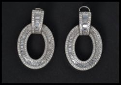 A pair of sterling silver and CZ earrings of roundel form. Weighs 11 grams.