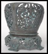 A 20th century cast bronze planter raised on splayed legs with floral sprays and medallions. The