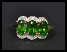 A 14ct gold ring having three tourmaline central panels surrounded by diamonds. Weighs 3.2 grams