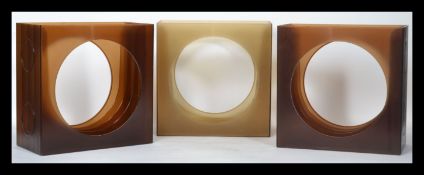 A collection of three plastic atomic style vinyl LP record storage units, each with a large circular