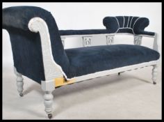 A late Victorian shabby chic chaise longue sofa settee being painted white with blue cord