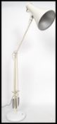 A vintage 20th century Herbert Terry anglepoise desk lamp being raised on circular base with a