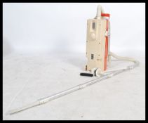 A retro 20th century 1970's orange Hoover / Vacuum cleaner  retaining attachments and tube in a