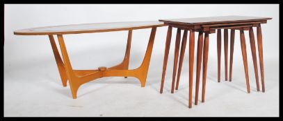 A 1970's atomic faux teak wood astral coffee table of lozenge form with inset glass top together