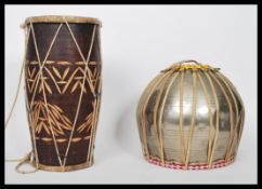 A 20th century African style tribal Djembe drum together with another drum constructed from