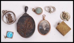 A group of silver gold and yellow metal jewellery pendants to include a hallmarked silver pendant,
