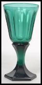 A stunning 19th century green glass wine glass having a conical bowl with slice cutting raised on