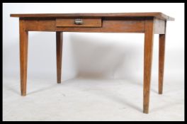 An early 20th century oak desk / farmhouse kitchen table, raised on square tapered legs, single