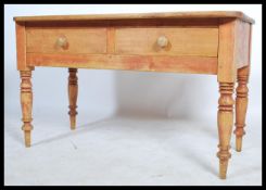 A late 19th century Victorian scrubbed pine desk, two drawers to the front raised on turned legs