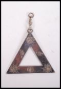 An unusual silver hallmarked Masonic triangular pendant by L SImpson & Co London. London hallmarks