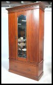 An Edwardian mahogany inlaid single wardrobe being raised on a plinth  base with a short drawer