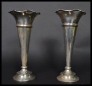 A pair of early 20th century silver hallmarked vases by Daniel George Collins raised on circular