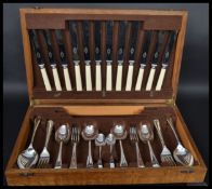 A good 20th century Art Deco satin wood canteen of cutlery, lift up lid opening to reveal a fully