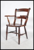 A 19th century Victorian beech and elm Oxford bar back Windsor carver chair raised on turned legs