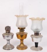 A  collection of three vintage 20th century oil lamps to include both brass and chrome examples, two