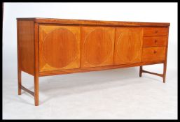 A mid century Nathan Furniture teak wood ' circles ' sideboard being  fitted with central two door