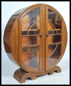A 1930's Art Deco oak china roundel display cabinet. The round circular cabinet with twin doors