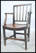 A 19th century Georgian beech and elm elbow / hall chair raised on turned supports and rails with