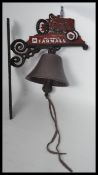 A vintage cast iron wall mounted bell in the form of a Farmall tractor. Measures 36 cm high.