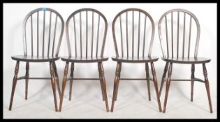 A collection of four vintage 20th century  beech and elm hoop back dining chairs in the manner of