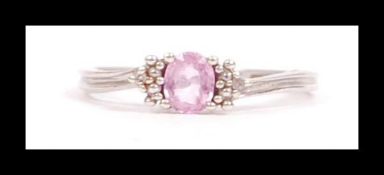 A 10ct white gold diamond and pink stone clusuter ring. Marked 10k. tests 10ct gold. Weight 1.2g.