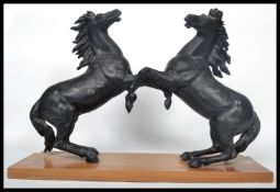 A pair of 19th century ebonised spelter marley horses rearing at each other being set over a