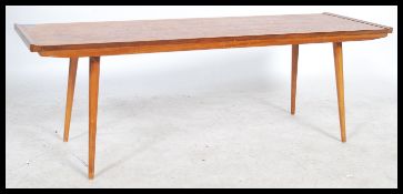 A 1970's retro teak coffee table, with a rectangular overhanging top raised on shaped supports
