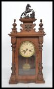 An early 20th century oak cased mantel clock having turned columns and carved applied decoration.